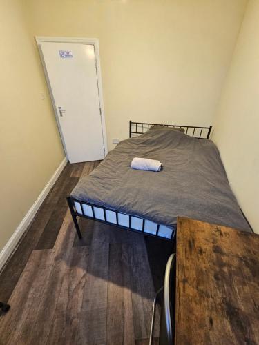 a bedroom with a bed and a table and a door at Double room with Shared Bathroom (3) in Manchester