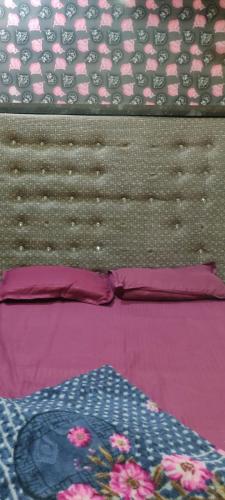 een bed met paarse en roze lakens en een sprei bij Rajs Lodging & Fooding (Guest House) in Calcutta