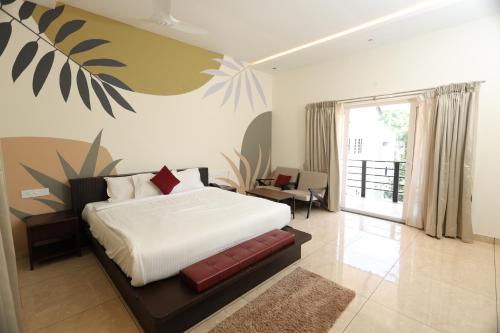 ein Schlafzimmer mit einem Bett mit einem Wandbild aus Pflanzen in der Unterkunft Queens Hotel -Yellow Lake Resorts &Spa -Yercaud in Yercaud
