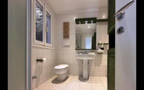 a bathroom with a toilet and a sink at Cà Alda – Lake Como View in Carate Urio