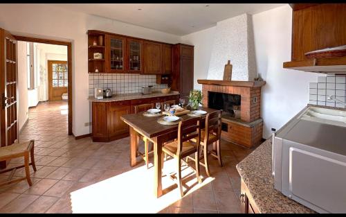 a kitchen with a wooden table and a fireplace at Cà Alda – Lake Como View in Carate Urio