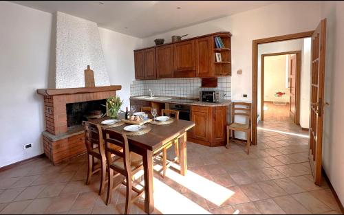a kitchen with a wooden table and a fireplace at Cà Alda – Lake Como View in Carate Urio