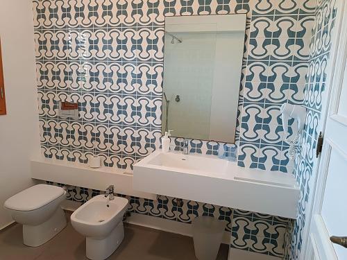 W łazience znajduje się toaleta, umywalka i lustro. w obiekcie Lo Scalo 2.0 w mieście Marina di Ragusa