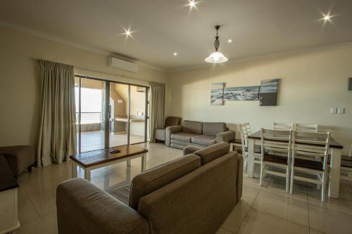 een woonkamer met een bank en een tafel bij Saints View Resort Unit 15 in Uvongo Beach