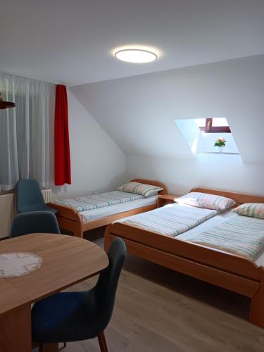 a room with three beds and a table and chairs at turistična kmetija pr mark in Trebče