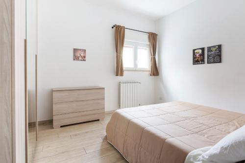 a bedroom with a bed and a dresser and a window at Luciano Secret Garden Apartment in Rome