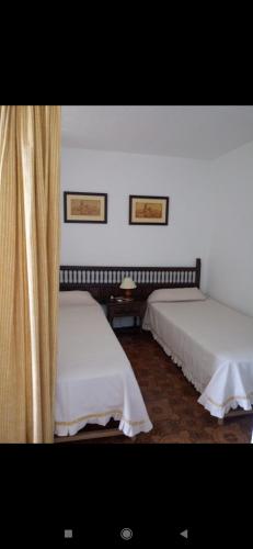 a bedroom with two beds and a curtain at Playa Las Fuentes in Alcossebre