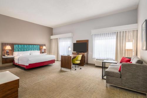 Habitación de hotel con cama, escritorio y sofá en Hampton Inn & Suites Hartford-Manchester, en Manchester