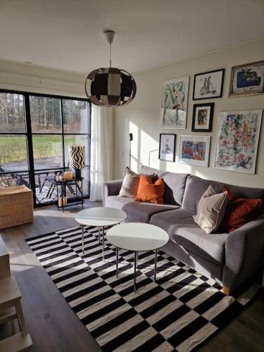 uma sala de estar com um sofá e duas mesas em The little house by the paddock em Gotemburgo