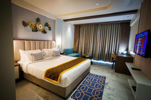a hotel room with a bed and a television at AJ GRAND ELITE HOTEL in Mangalore