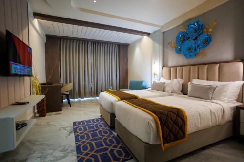 1 dormitorio con 1 cama grande y TV en AJ GRAND ELITE HOTEL, en Mangalore