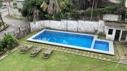 a swimming pool with lounge chairs next to a house at two flat in Douala