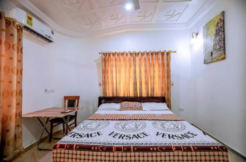 ein Schlafzimmer mit einem Bett und einem Schreibtisch. in der Unterkunft Crislord Palace Hotel in Takoradi