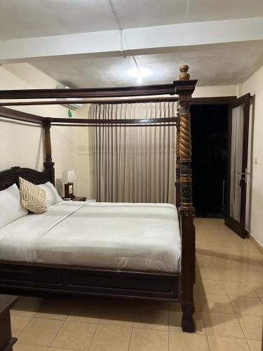 a bedroom with a bed with a wooden frame at Mai Malu in Pulukan