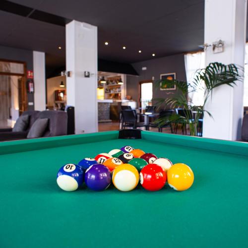 a pile of balls on top of a pool table at Pey Resort in Sort