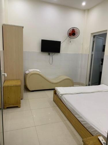 um quarto de hospital com uma cama e uma televisão na parede em Nhà nghỉ Thành Công em Da Nang