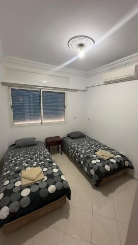 duas camas sentadas num quarto com em Appartement familiales em Al Hoceïma