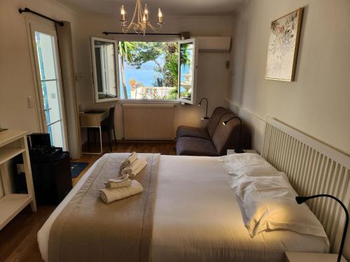 Cette chambre comprend un grand lit et une fenêtre. dans l'établissement Hôtel de Charme Brise Marine, à Saint-Jean-Cap-Ferrat