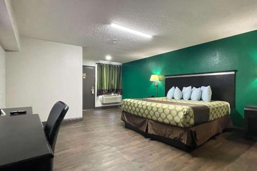 pokój hotelowy z łóżkiem i zieloną ścianą w obiekcie Rodeway Inn w mieście Georgetown