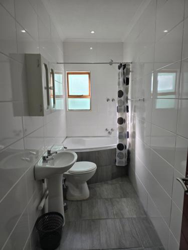 No8@Mosselbay - Central Mosselbay 1 Bedroom Apartment في خليج موسيل: حمام أبيض مع حوض ومرحاض