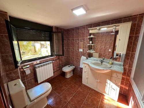 baño con lavabo y aseo y ventana en Increíble Casita de Pueblo. en Ugena