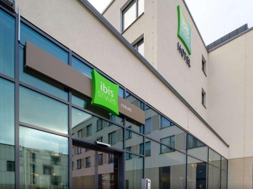 a building with two green signs on the side of it at ibis Styles Coburg in Coburg