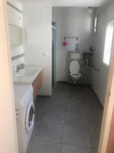 uma casa de banho com um lavatório e uma máquina de lavar roupa em Maison POUR OUVRIERS seulement PAS DE TOURISME, NI FAMILLE em Stains
