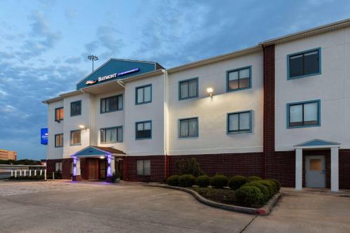 a large white building with a sign on it at Baymont by Wyndham Houston Brookhollow in Houston