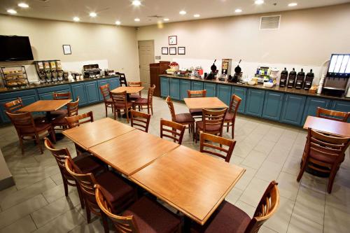 restauracja z drewnianymi stołami i krzesłami oraz blatem w obiekcie Country Inn & Suites by Radisson, Harrisburg West Mechanicsburg w mieście Mechanicsburg