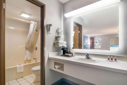 uma casa de banho com um lavatório, um WC e um espelho. em Econo Lodge em Branson