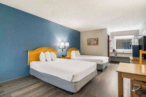 布蘭森的住宿－Econo Lodge，酒店客房设有两张床和蓝色的墙壁。