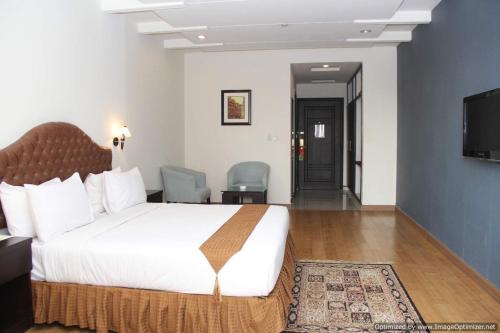 a hotel room with a bed and a television at Hotel Javson in Sialkot
