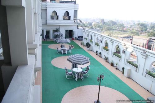 an outdoor patio with tables and chairs on a building at Hotel Javson in Sialkot