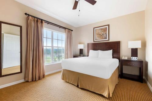 a bedroom with a large bed and a large window at Hilton Vacation Club Aqua Sol Orlando West in Orlando