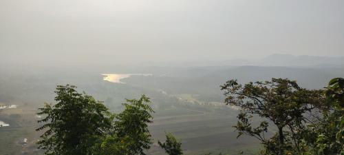 a view of a valley with trees in the foreground at Gitanjali Forest Retreat in Bāghmundi