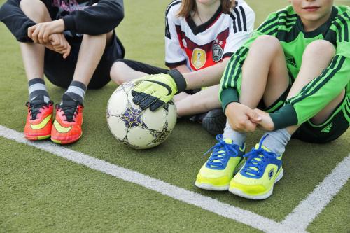 a group of young children sitting on a soccer field at Natürlich Hell. Aparthotel & Camping in Fügen