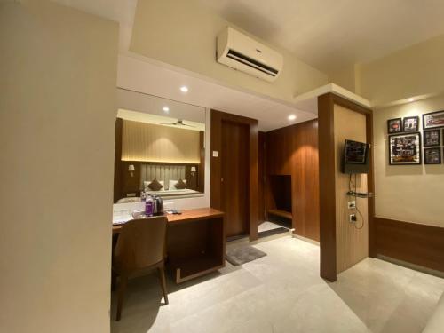 a hotel room with a desk and a bed at Hotel Czar Inn - Vashi Navi Mumbai in Navi Mumbai