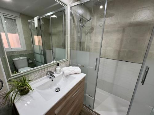 a white bathroom with a shower and a sink at Piso en Linares zona centro con parking gratis in Linares