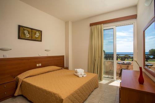 a bedroom with a bed and a sliding glass door at Al Mare Apartments in Afantou