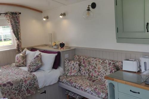 Shepherd Hut Enniskillen Blossom, Fermanagh في إنيسكيلين: غرفة معيشة مع أريكة وأريكة وطاولة