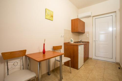 a small kitchen with a table and chairs and a door at Al Mare Apartments in Afantou