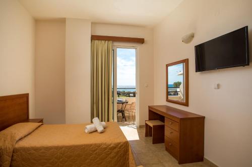 um quarto de hotel com uma cama e uma televisão em Al Mare Apartments em Afantou