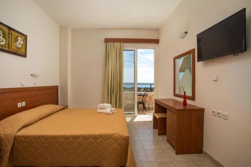 a bedroom with a bed and a flat screen tv at Al Mare Apartments in Afantou