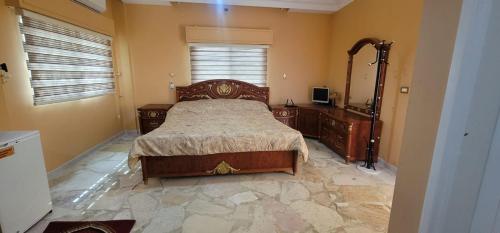 Schlafzimmer mit einem Bett, einem Waschbecken und einem Spiegel in der Unterkunft Um Al namel in Irbid