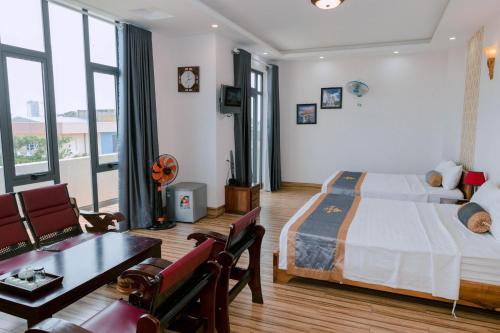 Khách sạn Phú Yên في Liên Trì (3): غرفة نوم مع سرير وغرفة معيشة