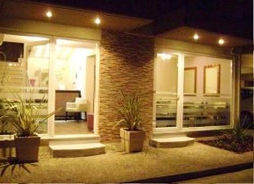 a house with potted plants in front of it at night at Thelxis in Volos