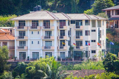 a large white building with flags in front of it at Hotel Lakefield in Kandy