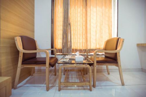 dwa krzesła i stół w pokoju w obiekcie Hotel Fun City (Best Review Hotel In Navsari) w mieście Navsāri