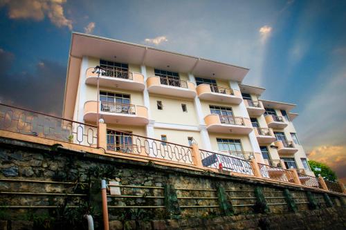 a white building with a balcony on the side of it at Hotel Lakefield in Kandy