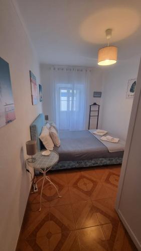 a bedroom with a bed and a table in it at Refugio dos Lima in Ericeira